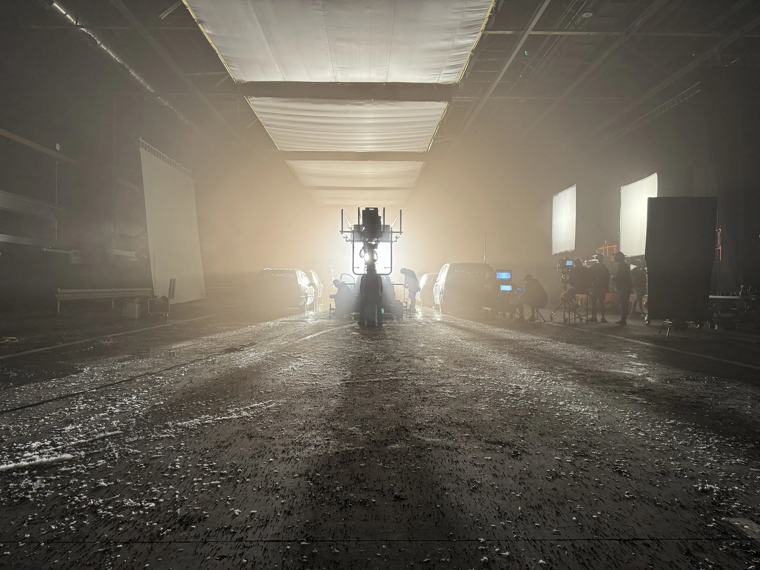 Film crew working on a soundstage beneath studio lights.